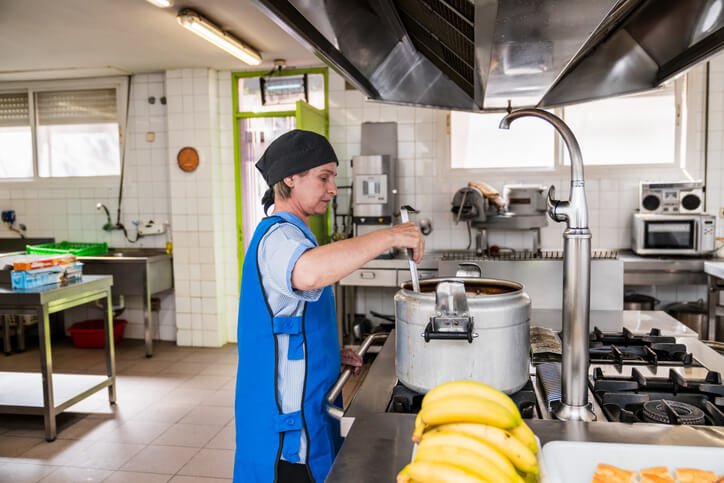 Weibliche Küchenkraft kocht für Seniorenheim